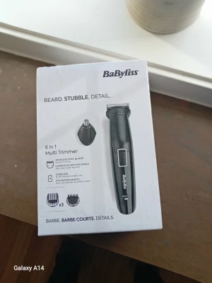 BaByliss 6 in 1 Multi Trimmer - BaByliss 6 in 1 Multi Trimmer är en svart trimmer med flera tillbehör för skägg och detaljtrimning. Den har rostfria stålblad, tre kammar och ett nästrimmerhuvud. Trimmern är sladdlös och har en modern, smal design i plast och metall.