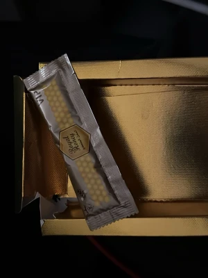 Royal Honey portionsförpackning - En portionsförpackning Royal Honey från VIP i guldfärgad förpackning. Förpackningen är rektangulär och dekorerad med honungskakemönster och guldfärgade detaljer. Perfekt att ta med i väskan eller använda till te och mat.