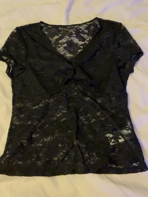 Svart spetsblus med v-ringning - Snygg svart blus i genomskinlig spets med korta ärmar och v-ringad hals, från shein i storlek “15Y” passar mej som har S🖤 aldrig andvänd!