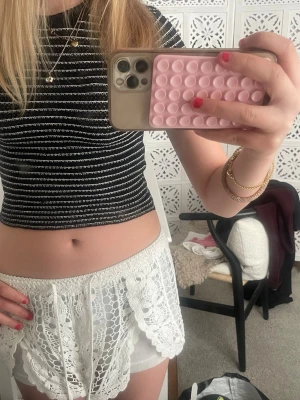 Svartvit randig croppad topp - Trendig croppad topp i svart med vita horisontella ränder. Kortärmad modell med tight passform och rund halsringning. Perfekt att matcha med höga jeans eller kjol. 