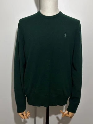 Polo Ralph Lauren Merinoull Crewneck Tröja - Polo Ralph Lauren Merinoull Mörk Grön Merino Crew Neck Pullover Hunt Club Green. I nyskick utan defekt. Storlek L men även funkar för M. Skriv från privat för måtten. Nypris är ca 2200 kr. Skickar alltid samma dag eller nästa dag. Skriv för mer information eller frågor. Allt vi säljer är äkta kläder.  Om du fått fel vara eller en defekt produkt, kontakta oss direkt via Plick meddelanden. Vi hanterar ärendet snabbt och smidigt för att lösa det för din fördel. 
