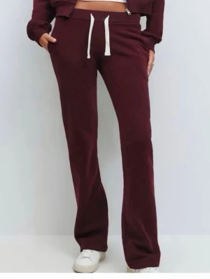 Nya Vinröda mjukisbyxor med raka ben från Gina tricot 14+ strl S - Snygga vinröda mjukisbyxor med raka ben och vit dragsko i midjan. Byxorna har en avslappnad passform och är tillverkade i mjukt material som känns skönt mot huden. Perfekta för en chill och trendig look.