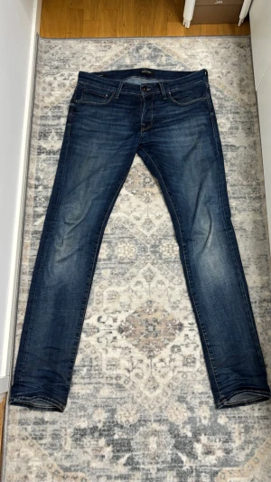 Jack & Jones Jeans Slim Glenn - Snygga mörkblå slim fit jeans från Jack & Jones med klassisk femficksdesign och goa fades på framsidan. Jeansen har raka ben och är tillverkade i ett stretchigt denim-material som ger en skön passform.