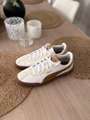 Puma vita och beige sneakers - Snygga sneakers från Puma i vitt och beige med bruna detaljer och gummisula. Skorna är sprillans nya och kommer med box! 