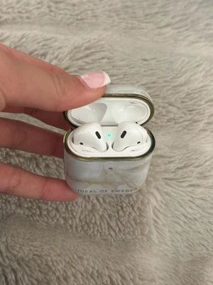 AirPods 2 - Säljer mina AirPods 2 då jag trodde jag hade tappat bort dem (köpte nya). Bra skick, lite äldre generation därav priset. De funkar galant! Fodral (skydd) ingår. Ideal of Sweden fodral. 