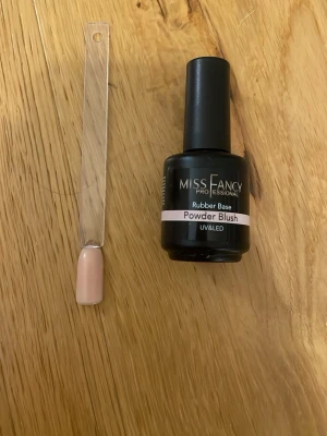 Miss Fancy Powder Blush nagellack - Miss Fancy Professional Rubber Base i färgen Powder Blush. Ett UV/LED-härdande nagellack i en mjuk, ljusrosa nyans. Perfekt för dig som gillar naturliga och eleganta naglar. Kommer i en klassisk rund flaska med svart lock.