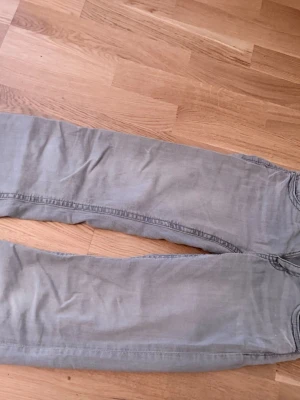 Grå jeans från Ginatricot - Snygga grå jeans från Ginatricot med klassisk femficksdesign och dragkedjegylf. Jeansen är i storlek 164 fast den på entlugt mig som är 166 och 52 kg är den lite lös med raka ben. Så om du letar efter byxor som inte är bootcut då är de perfekta för dig! Innan jag kommer frakta så kommer jag stryka så att de ser lite bättre ut;)