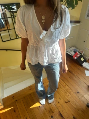 Vit puffärmad blus med knyt - Söt vit blus med puffärmar från Carin Wester. Blusen har två söta knytnings detaljer framtill och passar perfekt till jeans för en avslappnad men trendig look. Aldrig använd med prislapp kvar. Godkänner snabba prisförslag!