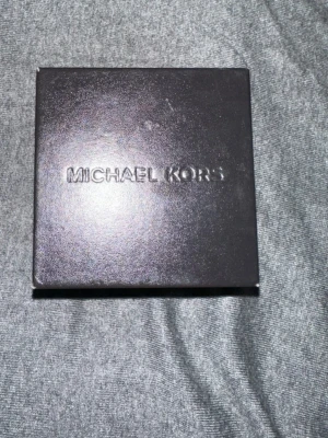 Michael Kors klockask - Säljer en snygg och stilren klocka från Michael Kors i svart med klockasken. 