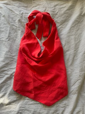 Röd halterneck topp - Snygg röd halterneck topp med knyt i nacken och baktill, helt öppen i ryggen😍😍aldrig använd