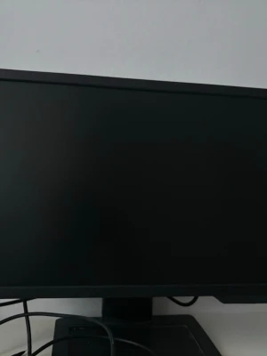 Svart datorskärm med tunn ram - En stilren svart datorskärm med tunn ram och rektangulär fot. Perfekt för gaming, studier eller arbete. Skärmen har en modern design och ansluts enkelt med kablar på baksidan.