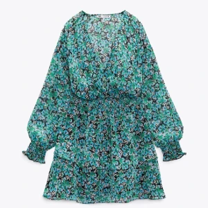 Blommig klänning från Zara - Säljer en vacker blommig klänning från Zara. Klänningen har långa ärmar med volangdetaljer vid ärmsluten och en v-ringad hals. Perfekt för en somrig dag!💕