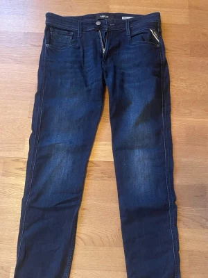 Replay Anbass Jeans Mörkblå - Mörkblå Replay jeans. Modell: Anbass. Storlek W31 L34. Priset ej hugget i sten vid en snabb affär! Skickar alltid inom 1 dag! Hör av dig vid minsta fråga!