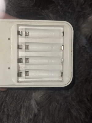 Batteriladdare från GP, vit - Säljer en vit batteriladdare från GP som laddar upp till fyra AA- eller AAA-batterier samtidigt. Laddaren är tillverkad i plast och har tydliga plus- och minusmarkeringar. Perfekt för dig som vill ladda uppladdningsbara batterier hemma.