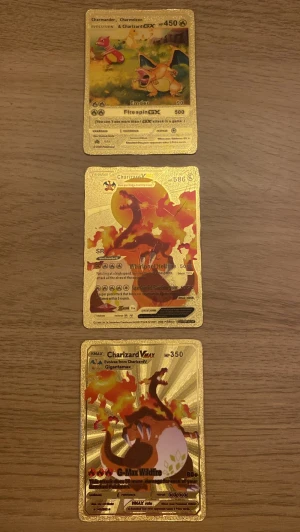 Charizard Pokémon guldfoilkort 3-pack - Säljer ett set med tre exklusiva Charizard Pokémonkort i guldfoil. Korten har en glansig guldfärgad yta och visar olika versioner av Charizard, inklusive GX och VMAX. Perfekt för samlare eller dig som vill ha något unikt i din kortsamling.
