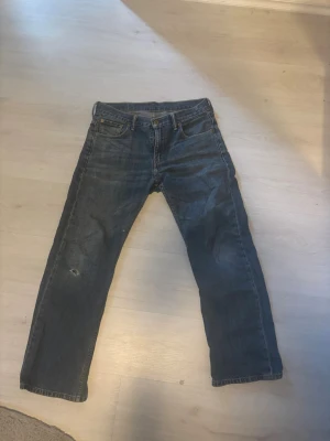 Levi's raka blå jeans - Klassiska blå jeans från Levi's med rak passform och fem fickor. Jeansen har en något tvättad look och är tillverkade i slitstarkt denimtyg. Perfekta för en avslappnad stil och funkar till det mesta. Sällan använda och modellen är 569. Strl W 30 L 30