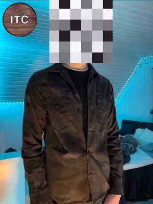 Replay Overshirt  - Stilren svart overshirt från Replay med klassisk krage och knäppning framtill. Två bröstfickor med lock och knappar ger en snygg touch. Perfekt lager-på-lager-plagg i mjukt material som passar till många olika outfits.