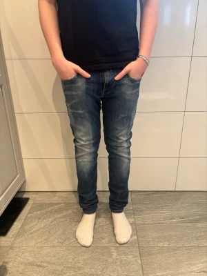 Replay anbass  - Snygga blå slim fit jeans från replay med tvättade detaljer och klassiska fem fickor. Jeansen har normal midja och smal passform hela vägen ner. Materialet är denim i bomull och de har coola sömmar på bakfickorna. Perfekta för en avslappnad och trendig look.