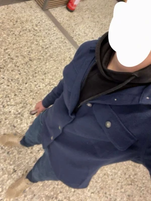 Mörkblå overshirt med fickor - Stilren mörkblå overshirt med knappar framtill och två bröstfickor med lock. Skjortjackan har klassisk krage och är tillverkad i ett tjockare tyg som ger en avslappnad men snygg look. Perfekt att bära över en hoodie eller t-shirt.