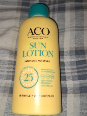 ACO Sun Lotion SPF 25 200ml - ACO Sun Lotion med SPF 25 ger medelhögt skydd mot solens strålar. Den är gul med turkost lock och text, och innehåller 200 ml. Lotionen är vattenresistent, kladdfri och har Triple Moist Complex för intensiv återfuktning. Perfekt för dig som vill skydda huden mot UVA och UVB.
