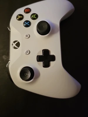 Vit Xbox Series X handkontroll - Snygg vit Xbox Series X handkontroll med svarta detaljer och färgade knappar. Ergonomisk design med två styrspakar, styrkors och klassiska Xbox-knappar. Tillverkad i slitstark plast och passar perfekt för gaming på konsol eller PC.