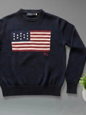 Mörkblå stickad tröja Ralph Lauren - Mörkblå stickad tröja från Ralph Lauren med amerikansk flagga i rött, vitt och blått på bröstet. Tröjan har rund halsringning, ribbstickade muddar och RL-broderi. Perfekt för dig som gillar klassisk college-stil.