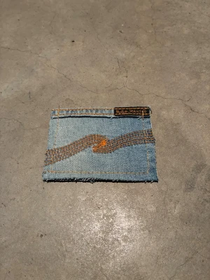 Jeansplånbok -  Dropp 7  Handsydd plånbok i vintage jeans. Varje exemplar är unikt med snygga detaljer. Plånboken håller flera kort utan att dem åker ut. Små variationer i färg och struktur visar på plaggets tidigare historia💙  Tiktok: Jeanius.bc