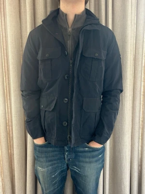 Woolrich field jacket - M - Fint skick, inga defekter. Modellen på bilden är ca 180 cm. Om du undrar över något tveka då inte på att höra av dig!