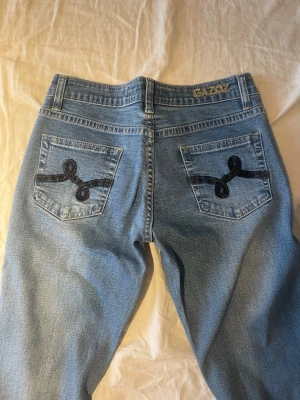 Blå bootcut jeans från Gazoz - Supersnygga jeans från märket Gazoz! Storlek S men skulle mer säga att de sitter som xs. Köpta på second hand. De är i mycket bra skick - använda 1-2 gånger. Pris kan diskuteras! Midjemått tvärsöver: ca 34cm
