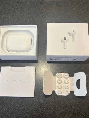 Apple AirPods Pro 3 trådlösa hörlurar - Är öppen för lägre pris. Säljer ett par vita Apple AirPods Pro med laddningsetui. Hörlurarna har in-ear design med silikonproppar och levereras i originalförpackning. Smidig touchkontroll och aktiv brusreducering för bästa ljudupplevelse. Perfekt för musik, samtal och träning.