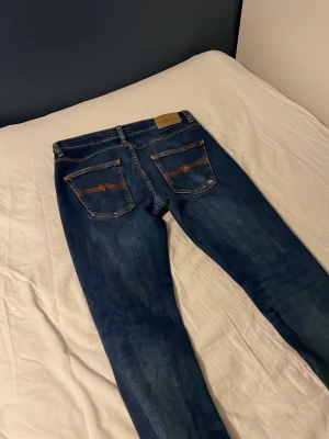 Nudie jeans grim tim - Ett par riktigt schyssta Nudie jeans. Färgen är indigo myth. Enda defekten är att det är lite trasigt vid under gylfen(bild4). Det går lätt att laga gratis i nudie butik.