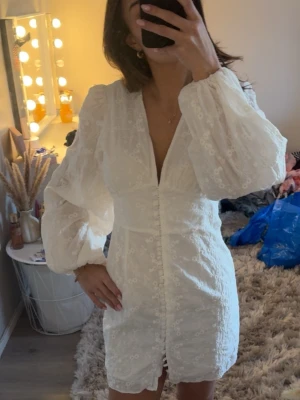 Vit klänning från ADOORE (läs beskrivning) - Super fin klänning från ADOORE i storlek 38 (passar även 36)🤍 Som jag tyvärr måste sälja på grund av att den tyvärr är för stor för mig!   OBS: Kolla bilder för att se att 4 av knapparna har tyvärr lossnat (se bild). Går att laga om man har lite tid men även därav sänkt pris pga skicket. Nypris 1495kr. Vid snabb affär kan pris absolut diskuteras!  I övrigt fint skick och en otroligt smickrande modell. Perfekt till student, midsommar eller sommarfest 🤍