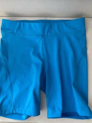 Blå träningstights shorts OTP - Säljer ett par blå träningstights shorts från OTP. Perfekt med blåshort inför träning i vår och sommar. Säljer då det inte passet mig längre.💙💙