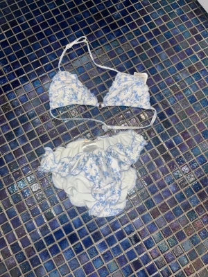 Vit och blå blommig bikini med volang - Superfin bikini i vitt med ljusblått blommönster och volangdetaljer. Perfekt till sommaren. TAR GÄRNA EMOT PRISFÖRSLAG❣️❣️