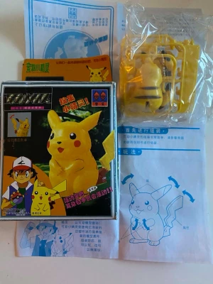 Pikachu byggsats Pokémon - Säljer en gul Pikachu byggsats från Pokémon med plastdelar och instruktioner. Figuren har rörliga öron och armar och kommer i originalförpackning med illustrationer av Ash och Pikachu. Perfekt för dig som gillar att bygga och samla Pokémonprylar. 3 år + 
