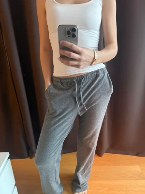 Grå mjukisbyxor - Säljer ett par klassiska grå mjukisbyxor med dragsko i midjan e och raka ben. Byxorna har fickor på sidorna och är supermjuka. Använda 1 gång. 