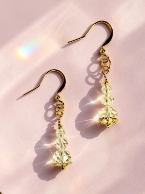 Guldörhängen med klara pärlor av kristallglas prismor  - Säljer ett par eleganta örhängen med guldpläterade krokar och detaljer samt tre klara, facetterade pärlor på varje örhänge. Pärlorna avslutas med en dekorativ guldfärgad blomdetalj. Perfekta för dig som gillar stilrena accessoarer med lite extra bling.