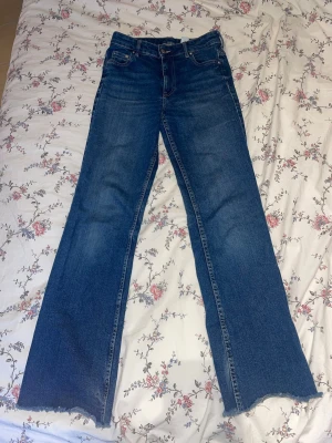 Blå bootcut jeans  - Säljer ett högmidjade par blå bootcut jeans. Jag klippte dom där nere eftersom dom var för långa men passar nu mig som är ca 160cm. Jag skulle säga att dom är lite mer mid rise än highwaisted, då dom är strax vid naveln. Jag har använt dom ett par gånger men dom har inga skador eller slitage. Dom är strechiga vid låren så dom kan anpassas till kroppsform 💙 Skriv gärna vid frågor!