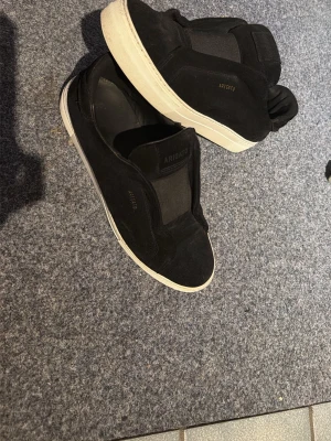 360 laceless sneakers från Axel Arigato - Svarta slip-on sneakers från Axel Arigato med ovandel i mocka och elastiska paneler. Skorna har en vit, tjock gummisula och minimalistisk design med diskret logga på sidan. Perfekta för en clean och stilren look. Skick 9/10. En modell som inte längre säljs så passa på! Hör av dig vid frågor eller funderingar🙏🏻😊OBS priset är diskuterbart