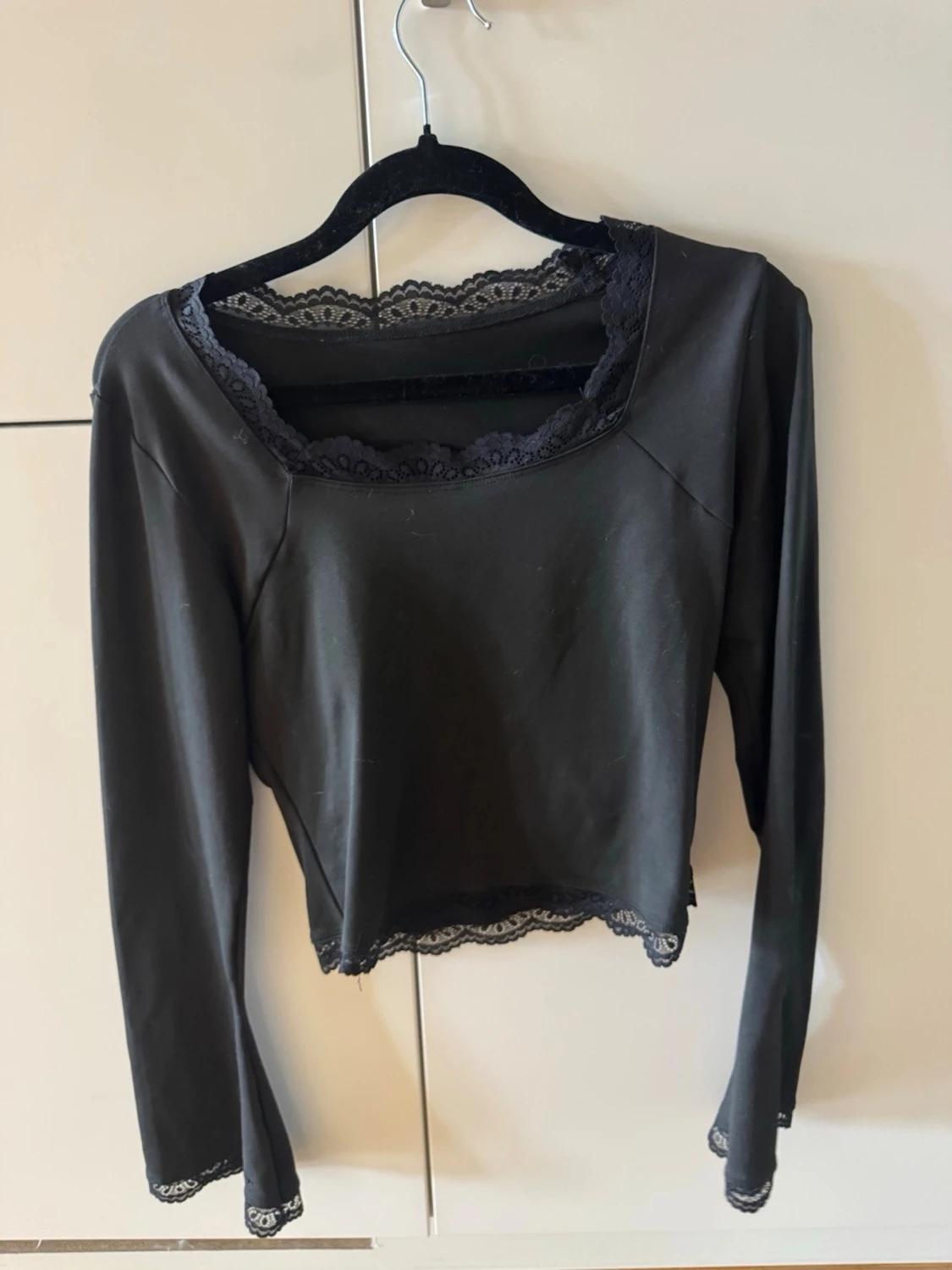 Svart croppad topp med spetsdetaljer