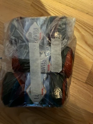 Flerfärgat garnpaket från LaVita - Säljer ett paket med flera nystan garn från LaVita. Garnet är flerfärgat i nyanser av blått, rött, orange och lila. Perfekt för dig som gillar att sticka eller virka egna projekt. 