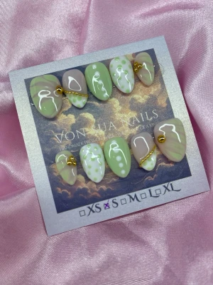 GreenBijou (S);Short Almond - Snygga handgjorda press-on naglar i grönt, nude med vita abstrakta mönster och prickar. Några naglar har guldfärgade kedjedetaljer för extra edge. Korta-Mandelformade och handgjorda i S: 15 mm, 11,5 mm, 12 mm, 11 mm, 9 mm. Perfekt för dig som vill ha unika naglar med cool design.