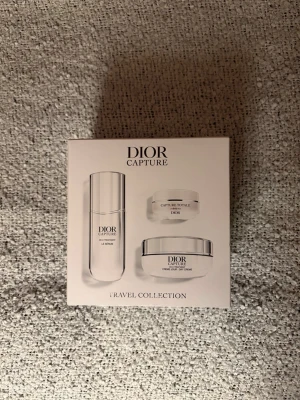 Dior Capture Travel Collection set - Lyxigt set från Dior Capture-serien med tre hudvårdsprodukter i resestorlek. Innehåller serum och två krämer i eleganta vita och silverfärgade förpackningar. Perfekt för dig som vill ha anti-age hudvård med hög prestanda i smidig förpackning. Nypris på taxfree är 3355kr. Förpackningen är oöppnad och försluten. Säljer på grund av dubbletter!✨