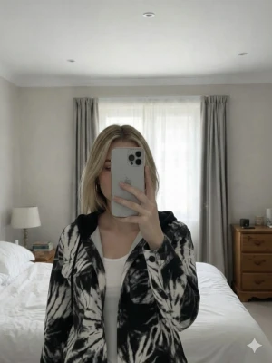 Svartvit overshirt med huva från Divided - Säljer en svartvit overshirt från Divided med tie-dye mönster och huva. Jackan har två stora bröstfickor, knäppning framtill och långa ärmar. Perfekt för dig som gillar streetstyle och vill sticka ut lite extra.