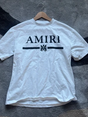 Vit t-shirt med tryck - Snygg vit t-shirt med svart logotyptryck framtill. Klassisk rund halsringning och korta ärmar. Perfekt för dig som gillar streetwear och vill ha en stilren look. Tillverkad i mjuk bomull för skön känsla hela dagen.