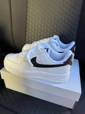  Nike Air Force 1 '07 Vita/Svarta Sneakers strl 38. - Helt nya & oanvända Nike Air Force 1 '07 Vita/Svarta Sneakers strl 38.  Skorna har inte blivit använda eller testade.  Original kartong medföljer! 