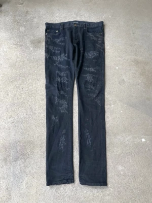 Saint Laurent FW2013 distressed scab denim by Hedi Slimane. - Waist: 90 cm Rise: 27 cm Inseam: 89 cm Length: 114 cm Hem: 16 cm Last pair online in the same size just sold for 600$+