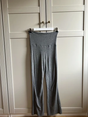 Grå ribbade leggings  - Säljer ett par grå leggings med ribbad struktur. Modellen har utsvängda ben och är tillverkad i ett mjukt, stretchigt material som sitter skönt på kroppen. Perfekta för en avslappnad och trendig look. Storlek 146/152 (inte 30)❤️