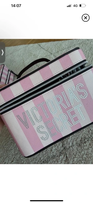 Söker!! Victoria's Secret rosa necessär - Jag söker en  necessär från Victoria's Secret med rosa och ljusrosa ränder, dekorerad med glittrande stenar på loggan.  