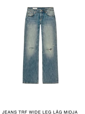 Wide leg jeans med låg midja från Zara - Snygga blå jeans med wide leg och låg midja från Zara TRF. Jeansen har slitna detaljer och hål på benen för en trendig look. Klassisk femficksmodell i denim med dragkedja och knapp. Perfekta för en avslappnad streetstyle.Hål där bak